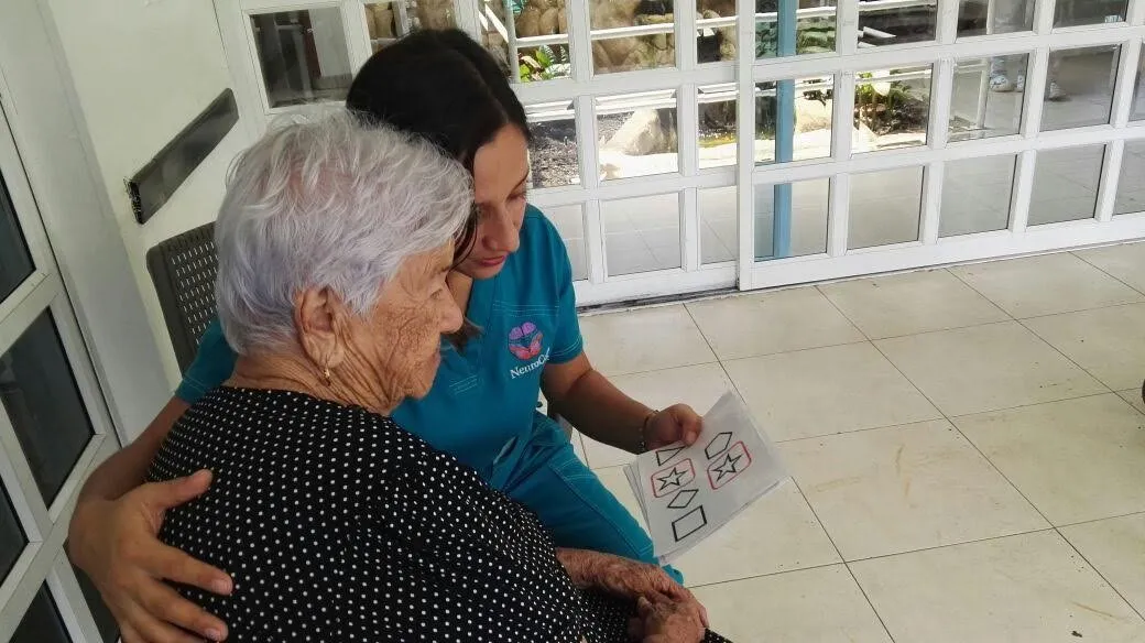 Cuidadora acompañando a un adulto mayor durante una actividad