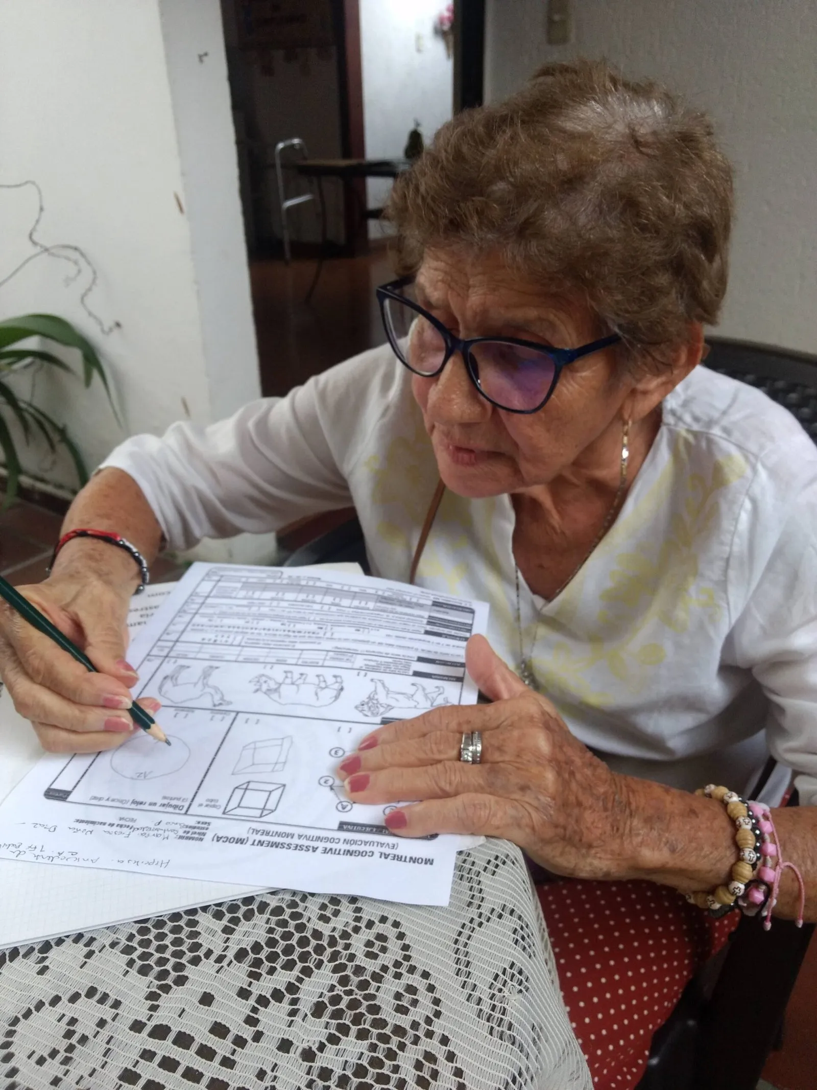 Adulta mayor resolviendo una evaluación cognitiva con lápiz y papel